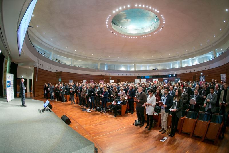 Auditorium gremito, pubblico in piedi davanti al palco